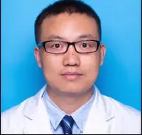 A dignified senior Chinese male orthopedic spine surgeon in white lab coat with stethoscope, warm professional clinical portrait, soft studio lighting.